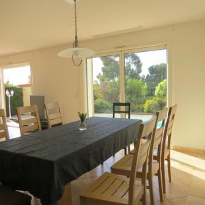 a dining room with a black table and chairs at villa 8 personnes piscine privée 8RJC12 in Saint-Laurent-de-la-Salanque +19 photos