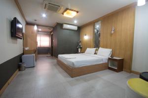 a bedroom with a bed and a television in it at Khon Kaen Ruenrom Hotel in Khon Kaen