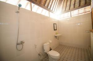 une salle de bain avec des toilettes blanches et une fenêtre dans l'établissement Ruji Ananta Cottage, à Nusa Penida 53 autres photos