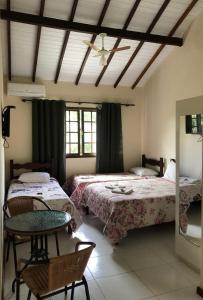 Un pat sau paturi într-o cameră la Itaipava Cama e Café