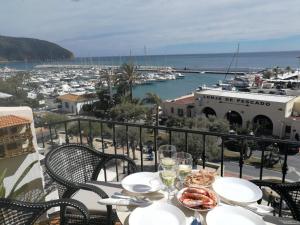 una mesa con copas de vino y vistas al puerto en vista al mar Habitacion en apartamento compartido, en Moraira
