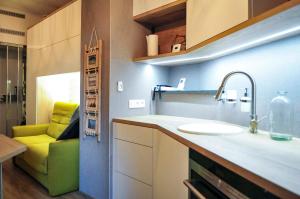 a kitchen with a sink and a green couch at Lodge 33 Eupen in Eupen +7 photos