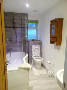 a bathroom with a tub and a toilet and a sink at Sammy's place in Hayle