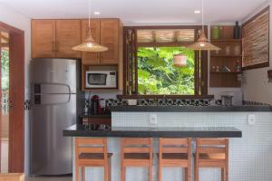 a kitchen with a stainless steel refrigerator and wooden cabinets at Linda casa em Itacaré Bahia in Itacaré