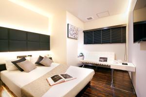 東京にあるHotel DUO kinsichoのベッド2台とデスクが備わるホテルルームです。