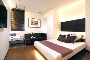 ein Schlafzimmer mit einem großen Bett und einem Schreibtisch in der Unterkunft Hotel DUO kinsicho in Tokio