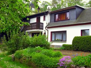 a white house with a garden in front of it at Pension Hänsel in Ehrenberg
