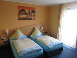 Postel nebo postele na pokoji v ubytování Hotel zur Burg Nürburg