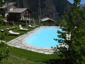 einen Pool in einem Garten mit Stühlen und einem Haus in der Unterkunft Affittacamere Le Relais De La Grandze in Doues