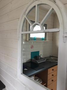 an arched window in a kitchen with a sink at Domki u Pana Zielonki in Rusinowo +87 photos