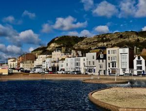 a group of white buildings next to a body of water at The Laindons in Hastings