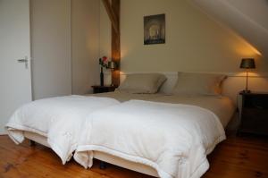 um quarto com 2 camas e lençóis brancos em 't Lankhof em Aalten