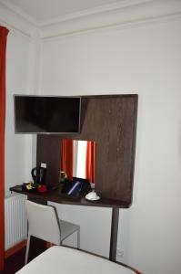 Cette chambre dispose d'un bureau et d'une télévision murale. dans l'établissement Parc Hotel, à Paris