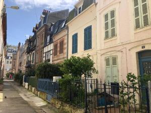 una hilera de casas en una calle con una valla en Appartement Trouville Plage, en Trouville-sur-Mer 17 fotos más