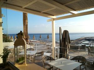 un restaurante con vistas a la playa, mesas y sillas en Hotel Gran Paradiso, en Isquia