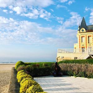 una persona sentada frente a un edificio con una torre de reloj en Appartement Trouville Plage, en Trouville-sur-Mer