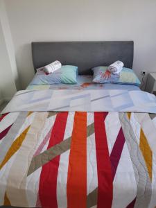 a bed with a colorful quilt on top of it at Niksin san in Trebinje +5 photos