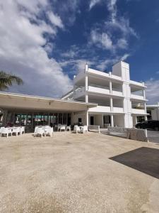 a large white building with white tables and chairs at L'eros Hotel in Ayia Napa