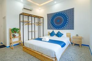 una camera da letto con un letto grande con cuscini blu di Santori Hoi An Villa, 6 BedRooms 11 Beds Private Pool, kitchen and Garden a Hiếu Nhơn Altre 63 foto