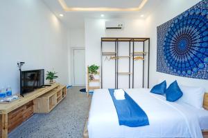 una camera da letto con un letto grande e una televisione di Santori Hoi An Villa, 6 BedRooms 11 Beds Private Pool, kitchen and Garden a Hiếu Nhơn
