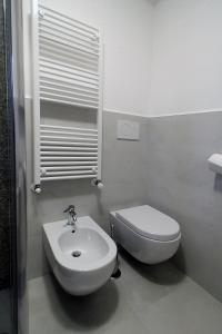 uma casa de banho com um WC branco e um lavatório. em Da nonno em Pezze di Greco