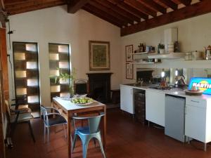 kuchnia ze stołem, krzesłami i kuchenką w obiekcie Podere Buonarosa w mieście Camaiore