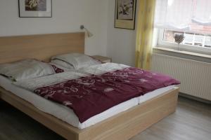 - un lit avec une couette et des oreillers violets dans une chambre dans l'établissement Am Kurzentrum 16, à Carolinensiel
