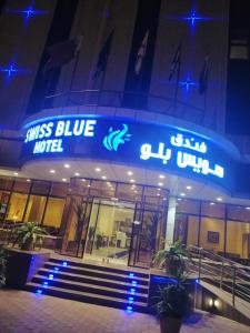a sign on the front of a building with blue lights at Swiss Blue in Jazan