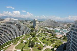 a view of a city with tall buildings and a park at Port Marina Baie des Anges in Villeneuve-Loubet