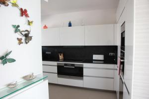 a kitchen with white cabinets and a stove top oven at Port Marina Baie des Anges in Villeneuve-Loubet