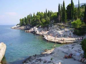 a group of people on a beach near the water at Apartments Senko in Trpanj