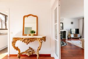 a mirror on a console table in a living room at Luxury Apart' MONS City Center with Terrace in Mons