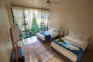 een slaapkamer met 2 bedden en een groot raam bij Kapievi Ecovillage in Puerto Maldonado