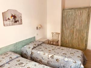 1 Schlafzimmer mit 2 Betten und einem Stuhl in der Unterkunft approdoflat in Isola Rossa