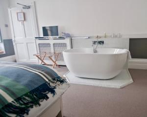 
a bath room with a bath tub and a toilet at The Laindons in Hastings
