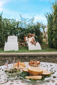 a table with a plate of food and a woman sitting in a chair at Hotel Al Mulino in Anacapri