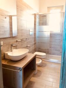 ein Bad mit einem Waschbecken, einem WC und einer Dusche in der Unterkunft approdoflat in Isola Rossa