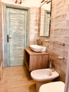 ein Badezimmer mit einem Waschbecken, einem WC und einem Spiegel in der Unterkunft approdoflat in Isola Rossa