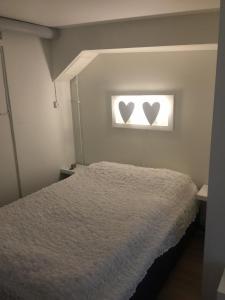 a bedroom with a bed with two hearts in a window at Hällestrand Apartment 32 in Strömstad