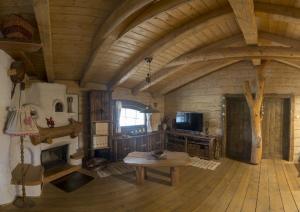 a large wooden room with a table and a tv at Hobití dom in Spišský Štiavnik