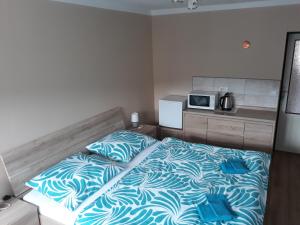 ein kleines Schlafzimmer mit einem Bett und einer Mikrowelle in der Unterkunft Ubytování Schindler in Velké Poříčí