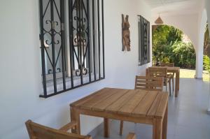 a dining room with a wooden table and chairs at Vokundahouse in Kololi