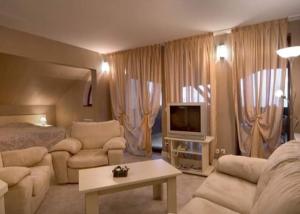 a living room with a bed and a living room with a television at Hotel Temenuga in Panichishte +6 photos