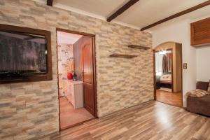 a living room with a stone wall at Apartament Słoneczna in Zakopane