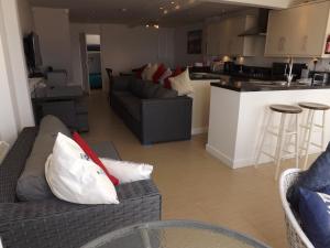 a living room with two couches and a kitchen at Seagull's Crest in Camber