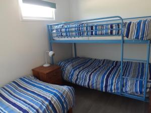 a bedroom with two bunk beds and a night stand at Seagull's Crest in Camber