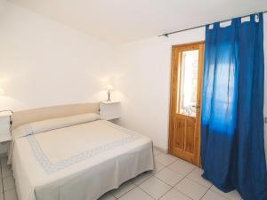 ポルト・オッティオルにあるLe Maree Il Vecchio Pozzoのベッドルーム1室(青いカーテンとドア付きのベッド1台付)