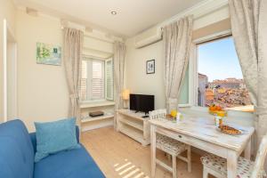 a living room with a table and a blue couch at Siesta Ragusa in Dubrovnik