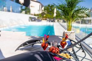a table with drinks on it next to a pool at Villa Valis in Baška