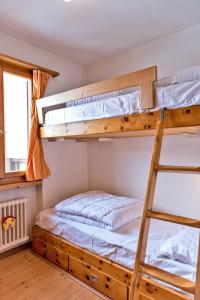 a bedroom with bunk beds and a ladder at Chesa Dal Gial - Celerina in Celerina